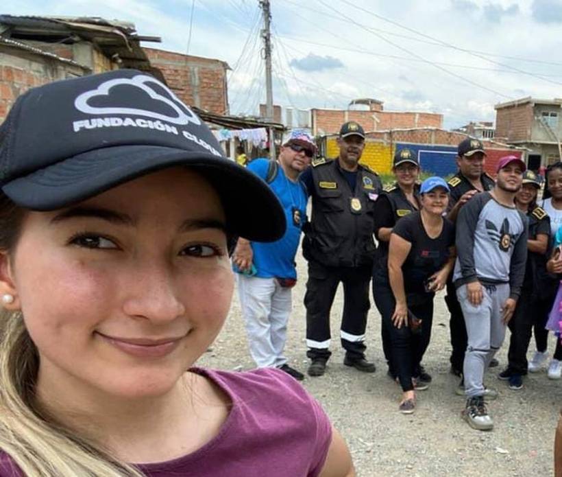A Fundación Cloud staff member with volunteers and uniformed Colombian National Police officers at a neighbourhood outreach.