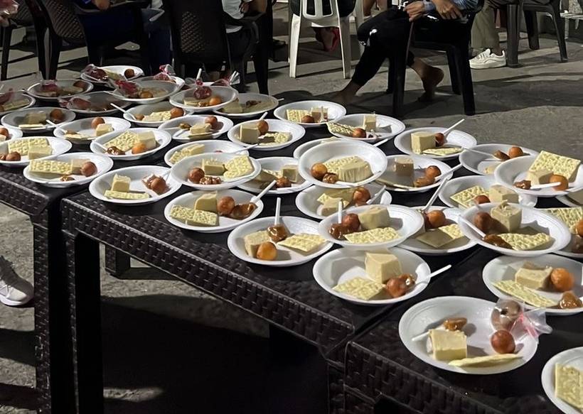 Dozens of plates of food laid out in rows on tables at the El Calvario food centre, ready to be served.